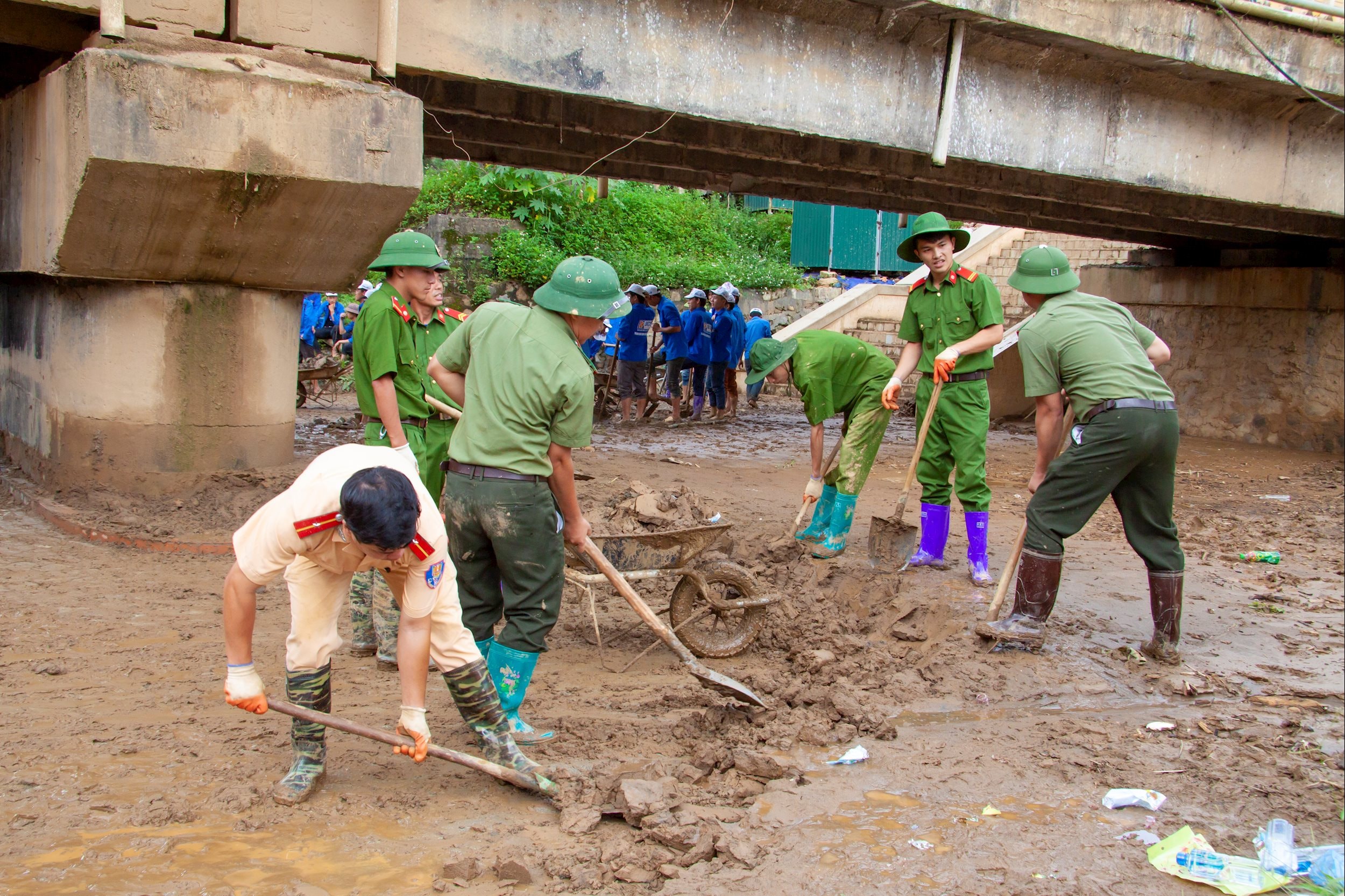 Các chiến sĩ Công an huyện Mù Cang Chải dọn bùn đất dưới cầu sau lũ dữ_Tác giả TRẦN TRUNG HIẾU