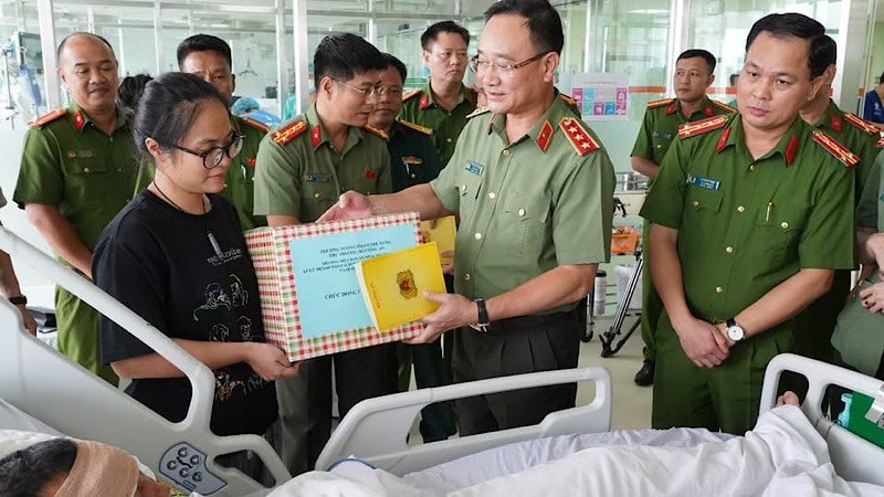 Thứ trưởng Phạm Thế Tùng động viên, tặng quà Đại úy Lê Đình Công.