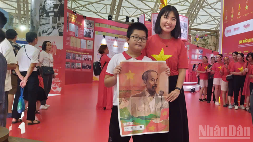 Chị Nguyễn Thị Hồng Nhung và con trai hiện đang sinh sống tại Sơn Tây (Hà Nội),chia sẻ, chị và cảm thấy rất may mắn khi tới tham quan triển lãm lần này rất ý nghĩa lại may mắn được tặng số phụ san của Báo Nhân Dân. 