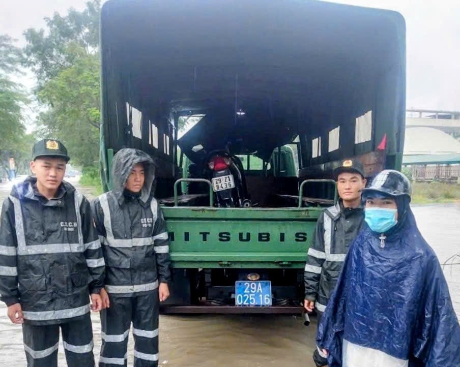 Người dân được xe chuyên dụng của Cảnh sát Cơ động Hà Nội hỗ trợ chở xe máy đi qua tuyến đường ngập nước. (Ảnh: QUỲNH LAN) z7090255369421-e8747ea9fc89ee2548317f73174451ff.jpg