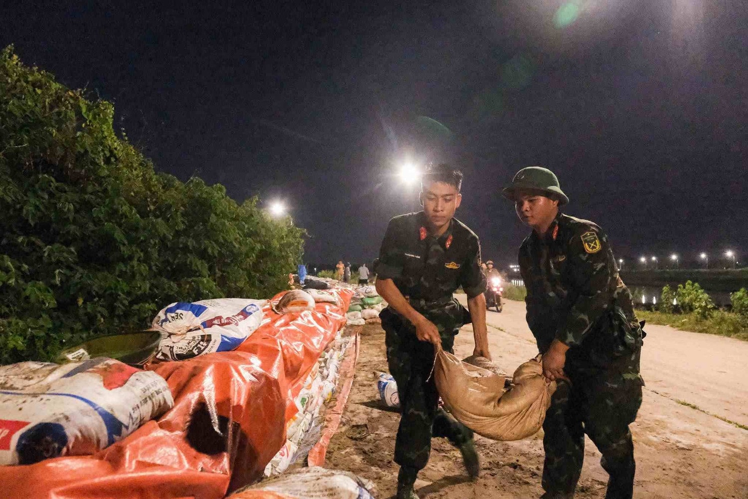 Cán bộ, chiến sĩ Bộ Chỉ huy Quân sự tỉnh Bắc Ninh khẩn trương gia cố đê Đẩu Hàn. (Ảnh: VÂN TRƯỜNG) a.jpg