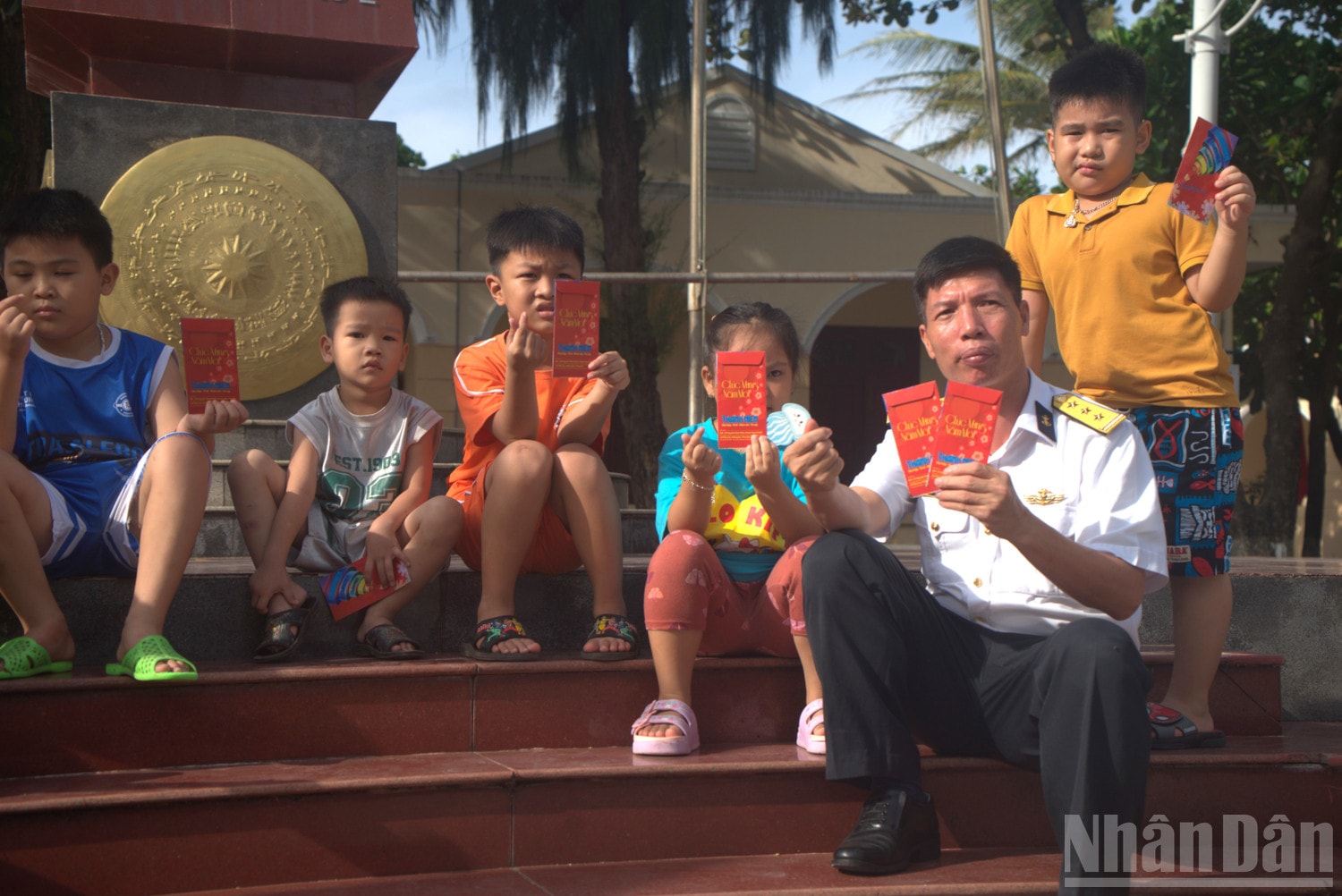 Thượng tá Phạm Sỹ Thoại lì xì Tết các thiếu nhi trên đảo Sinh Tồn nhân dịp Tết Nguyên đán Bính Ngọ 2026. (Ảnh: TRUNG HƯNG) ndo_br_dsc01561.jpg