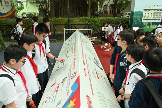 [Ảnh] Người dân đội mưa xếp hàng, háo hức nhận phụ san đặc biệt của Báo Nhân Dân